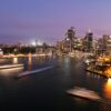 Captivating view of Sydney's illuminated skyline with the iconic Opera House and harbor at night.